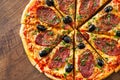 Pizza with Mozzarella cheese, salami, pepper, pepperoni, olives, Spices and Fresh Basil. Italian pizza on wooden background Royalty Free Stock Photo