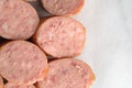 Slices of Polska Kielbasa on a gray marble cutting board.