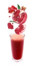 Slices of pomegranate fall into a glass of fresh j