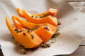 Slices of pumpkin with spices on parchment paper