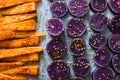 Slices of purple sweet potatoes sprinkled with sesame seeds and carrots