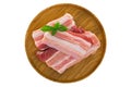 Slices of raw fresh pork belly cut on wooden plate isolated on w