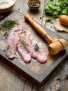 Slices of raw meat schnitzel on a beautiful wooden cutting board Royalty Free Stock Photo