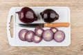 Slices of red onion and kitchen knife on cutting board Royalty Free Stock Photo