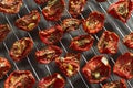 Slices of red tomatoes sun-dried arranged on metal grid. Healthy vegetarian food Royalty Free Stock Photo
