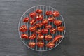 Slices of red tomatoes sun-dried arranged on round metal grid. Top view Royalty Free Stock Photo