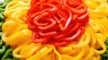 Slices of red and yellow bell pepper on a wooden plate. Closeup view. Sliced pepper background