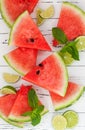 Slices of ripe juicy organic watermelon on old wooden table, served with fresh lime and mint leaves. Watermelon mojito ingredients