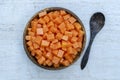 Slices of sweet papaya in coconut bowl on white wooden background, close up Royalty Free Stock Photo