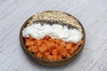 Slices of sweet papaya with oat flakes, chia seeds and white yogurt in coconut bowl on white wooden background, close up Royalty Free Stock Photo