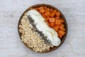 Slices of sweet papaya with oat flakes, chia seeds and white yogurt in coconut bowl on white wooden background, close up Royalty Free Stock Photo