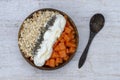 Slices of sweet papaya with oat flakes, chia seeds and white yogurt in coconut bowl on white wooden background, close up Royalty Free Stock Photo