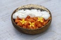 Slices of sweet papaya with oat flakes, chia seeds and white yogurt in coconut bowl on white wooden background, close up Royalty Free Stock Photo