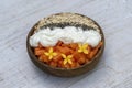 Slices of sweet papaya with oat flakes, chia seeds and white yogurt in coconut bowl on white wooden background, close up Royalty Free Stock Photo