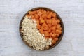 Slices of sweet papaya with oat flakes in coconut bowl on white wooden background, close up Royalty Free Stock Photo