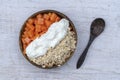 Slices of sweet papaya with oat flakes and white yogurt in coconut bowl on white wooden background, close up Royalty Free Stock Photo