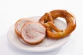 Slices of rolled roast, suckling pig, with pretzel on plate Royalty Free Stock Photo
