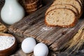 Slices of rye bread, ears of wheat, eggs and a bowl of flour. Close-up Royalty Free Stock Photo
