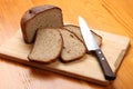 Slices of rye bread and a kitchen knife on a cutting board Royalty Free Stock Photo