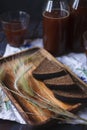 Slices of rye bread and rye spikelets on wooden plate with a bottle and a glass of kvass - the product of rye bread fermentation, Royalty Free Stock Photo