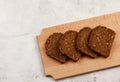 Slices of rye bread on a wooden cutting board on a light gray background Royalty Free Stock Photo