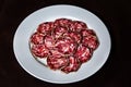 delicious slices salami dish on dark background