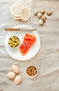 Slices of Salted Raw fish fillet with olive, quail eggs and nuts on white plate.Top view. Selection of good fat sources - healthy Royalty Free Stock Photo