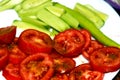 Slices of salted tomatoes with cumin, cucumber and hot green pepper in a white plate, healthy food concept