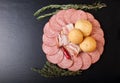 Slices of sausage and bacon on a cutting board with bread rolls, Royalty Free Stock Photo