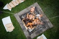 Slices of sausage, bacon and onion roasted on bonfire flame in garden