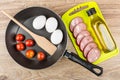 Slices of sausage, vegetable oil on cutting board, frying pan Royalty Free Stock Photo