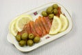 Slices of a smoked humpback salmon with olives and a lemon Royalty Free Stock Photo