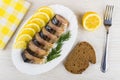 Slices of smoked mackerel with lemon in dish, napkin, bread Royalty Free Stock Photo