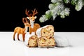 Slices of sweet stollen with nuts and dried fruit on table with toy deers and snow-covered spruce branch Royalty Free Stock Photo