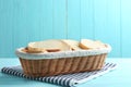 Slices of tasty fresh  in wicker basket on light blue wooden table Royalty Free Stock Photo