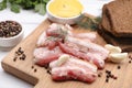 Slices of tasty pork fatback with garlic, rye bread and sauce on wooden board, closeup Royalty Free Stock Photo