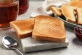 Slices of tasty toasted bread, jam and tea on light grey table Royalty Free Stock Photo