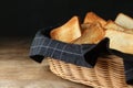 Slices of toasted bread in basket on wooden table against black background Royalty Free Stock Photo