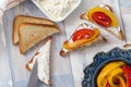 Slices of toasted bread with white soft cheese and fried bell peppers