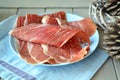 Slices of traditional tasty spanish marbled ham on blue dish