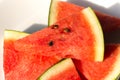 Slices of watermelon on a white plate with sunlignt in the morning.