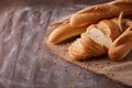 Slices of white bread with baguette on burlap on the dark wooden table, Space for text Royalty Free Stock Photo