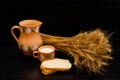 Slices of white bread, a cup of milk and a jug, a sheaf of wheat ears on a black table Royalty Free Stock Photo