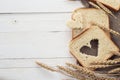 Slices of white bread and wheat ears on sacking on white boards. Royalty Free Stock Photo