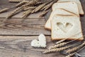 Slices of white bread and wheat ears on sacking on a wooden tabl Royalty Free Stock Photo