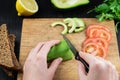 Slicing avocado for healthy sandwich, top view