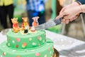 Slicing the Birthday cake with candles and Winnie the Pooh