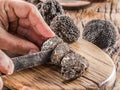 Slicing of black winter truffles. Black truffles and truffle slices on wooden board Royalty Free Stock Photo