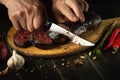 Slicing blood sausage by the hands of a chef on a cutting board. Cooking national dish on the kitchen table Royalty Free Stock Photo
