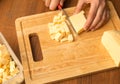 Slicing cheese with a knife on the board Royalty Free Stock Photo